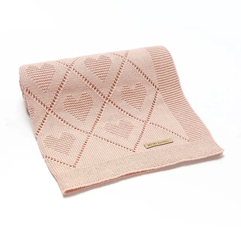 Couverture bébé rose pliée avec motif cœur en tricot doux et respirant