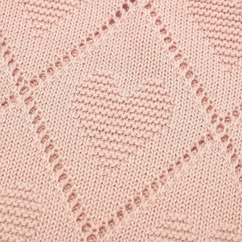 Motif cœur en tricot rose sur couverture bébé vintage en coton doux