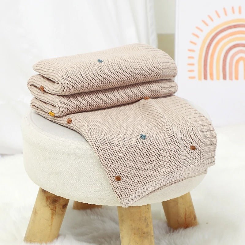 Couverture étape bébé Douceur Infinie posée sur un lit en coton léger