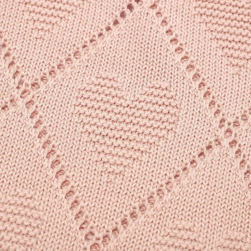 Motif cœur en tricot rose sur couverture bébé vintage en coton doux