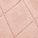 Motif cœur en tricot rose sur couverture bébé vintage en coton doux