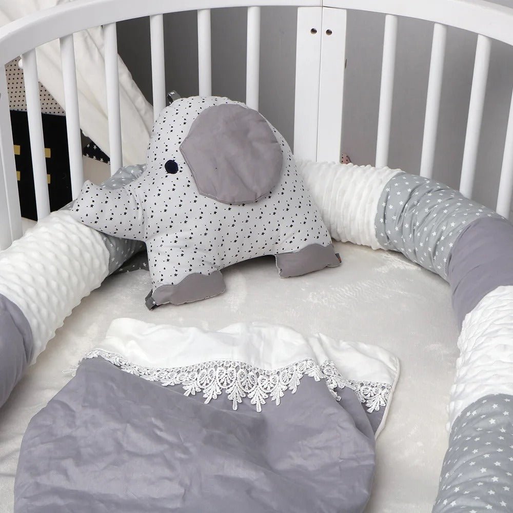 Tour de lit bébé gris étoilé en coton dans un lit bébé